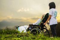 osoba niepełnosprawna na wózku i wolontariusz