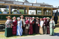 Grupa Seniorek ubrana w suknie pozuje do zdjęcia na tle zabytkowego tramwaju w ramach Dni Otwartych MPK Wrocław