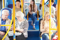 Zdjęcie przedstawia 7 siedzących osób - pasażerów w autobusie. 