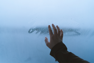 canva - obrazek poglądowy przedstawia wyciągnietą dłoń, która dotyka zaparowaną szybę z okna