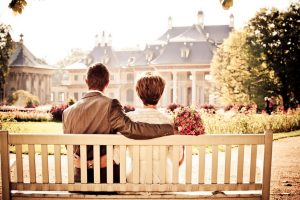 pixabay-małżeństwo siedzące na białej drewnianej ławce w parku w tle pałac 