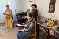 Trzy seniorki przeprane w stroje z epoki, podczas występu w DPS.