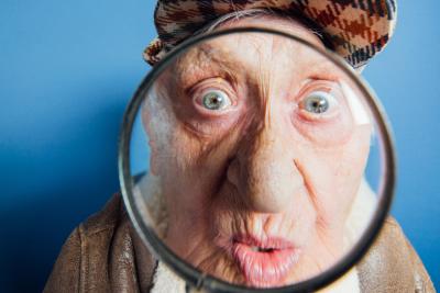 Na zdjęciu jest senior z lupą