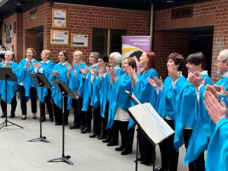 Na zdjęciu chór w niebieskich bluzkach w ramach międzypokoleniowego kolędowania Dni Babci i Dziadka 2025.